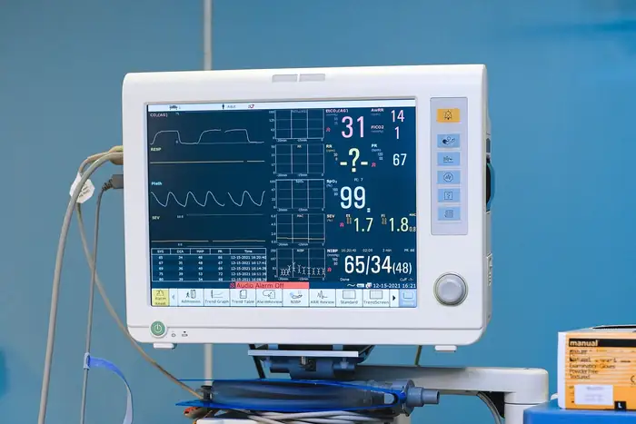 A patient monitor showing waveform traces and numeric readings