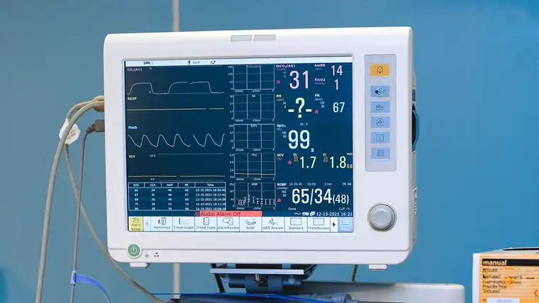 A patient monitor showing waveform traces and numeric readings